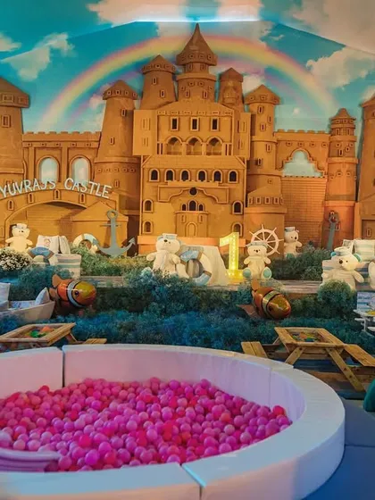 A dedicated kids' play area at the nautical party, featuring a massive sandcastle backdrop and a pink ball pit. I ensure that even the youngest guests have a magical, themed experience.