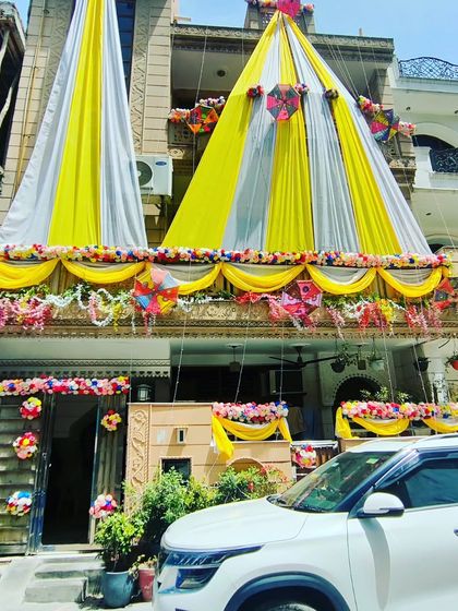 The yellow and white draping creates a grand and cheerful welcome, perfect for daytime wedding ceremonies.