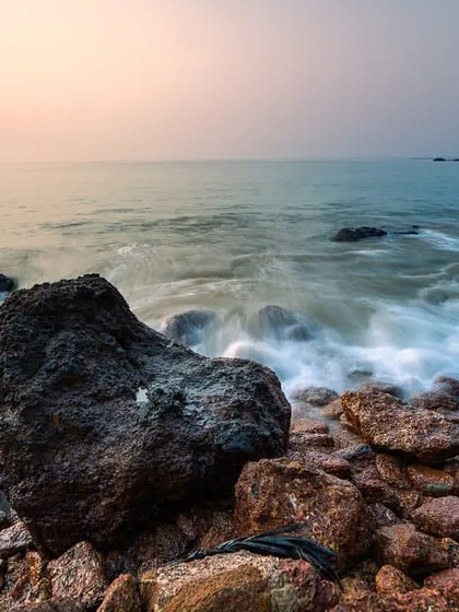 The motion of the waves creates a soft, flowing effect around the rocks on a beach in South Goa. This long exposure was taken just as the sun was rising.