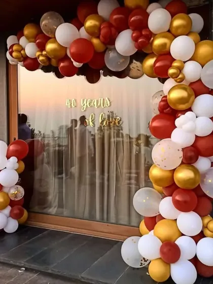 A classic balloon arch is a simple and effective way to decorate for any party. This red, white, and gold arrangement perfectly frames the entrance for a 40th birthday celebration.