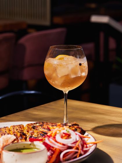A delicious pairing from one of our pop-up events. Grilled chicken is served alongside a refreshing gin-based cocktail, a perfect match of smoke and botanicals.