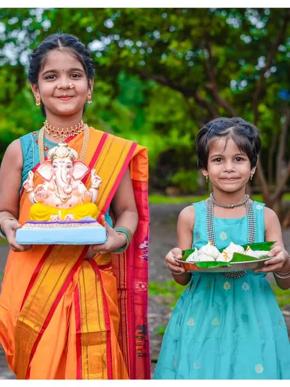 It gives me so much joy to photograph the spirit of our festivals. Here, sisters Nihira and Avani celebrate Ganesh Chaturthi, one holding a beautiful Bappa idol and the other a plate of modaks. These are the precious cultural memories I love to preserve for families.