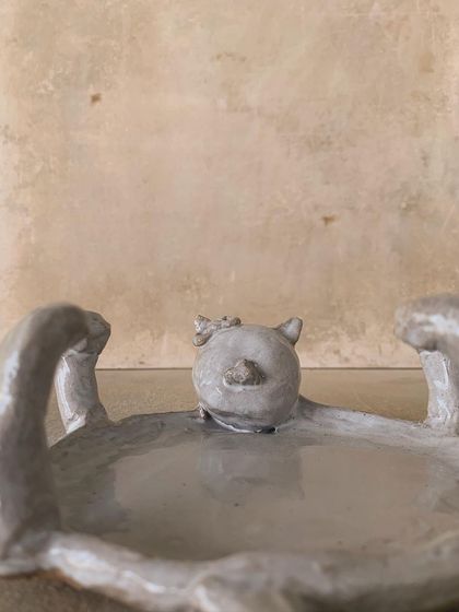 A close-up of the quirky, cat-shaped dish. Its playful, imperfect form is a celebration of the fun side of pottery.