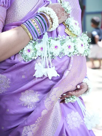 A close-up of the floral kamarband (waistband) from the baby shower set, showing the delicate arrangement of white orchids and baby's breath.