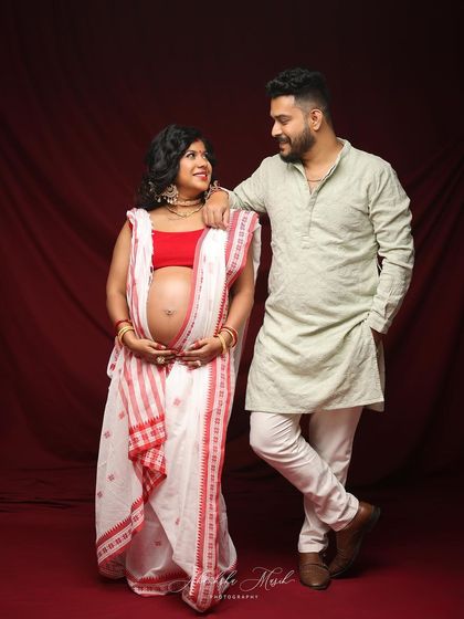 A beautiful portrait of an expecting couple in traditional Bengali attire. Their loving gaze towards each other speaks volumes.