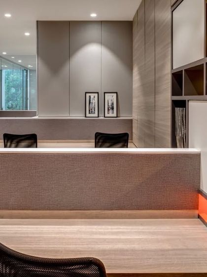A view of the Pharmaserve office project. The design uses low partitions to maintain an open feel, while the pops of orange in the shelving create a vibrant and energetic workspace.