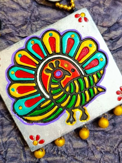 A duplicate close-up of the square block-printed peacock pendant.