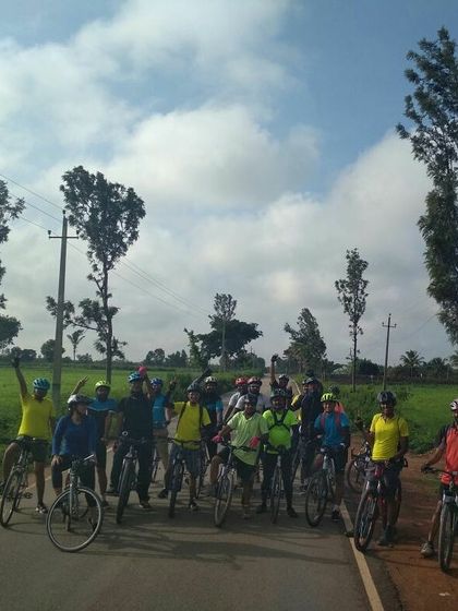 The crew celebrating on a country road, surrounded by fields and blue skies.