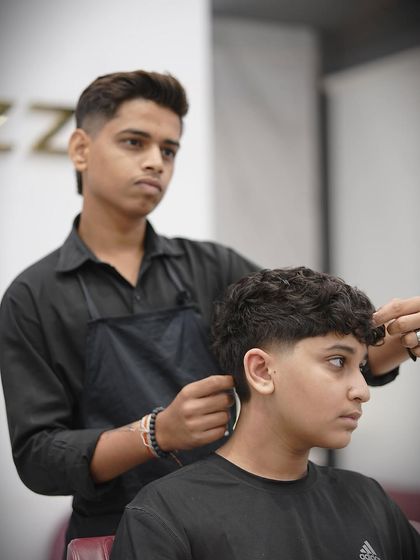 Here's one of my stylists working on the taper fade, ensuring every detail is perfect.