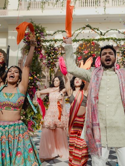 A high-energy group performance at a Mehendi, with colorful props and joyful expressions. This shot perfectly captures the celebratory vibe of a daytime wedding event.