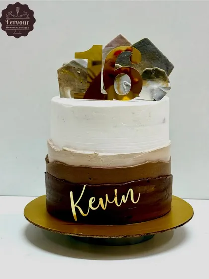 A modern chocolate cake with a three-tone ombre effect. This cake is decorated with isomalt shards and a custom name topper for a stylish finish.