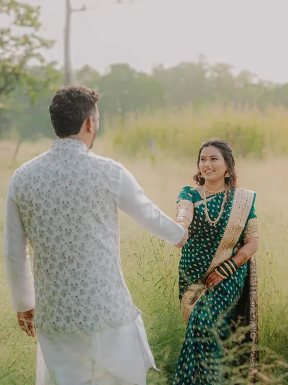 A beautiful shot of the groom leading his bride through a sun-drenched field. This image has a lovely, story-like quality, full of warmth and romance.