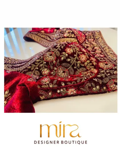 A close look at the rich Zardosi and thread work on a classic red velvet bridal blouse. This traditional design is a favorite for the main wedding ceremony, embodying timeless elegance and heritage craftsmanship.