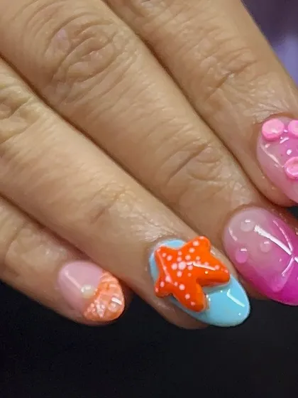 Another view of the holiday beach nails, with a bright orange 3D starfish and other sea-themed accents.