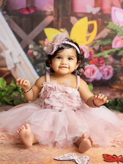 A butterfly themed first birthday. This little girl is sitting in a magical garden, ready for her cake smash celebration.