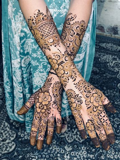 A crossed-hands pose showing the beautiful symmetry of the floral design. This is a popular choice for brides and guests alike.