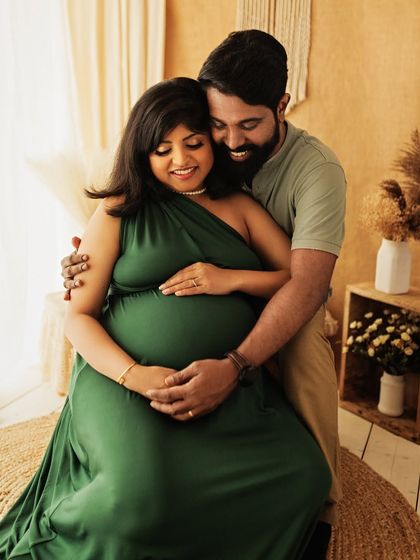 A close, loving embrace during a boho-themed maternity shoot. The earthy tones and natural textures of the studio complement the couple's connection.