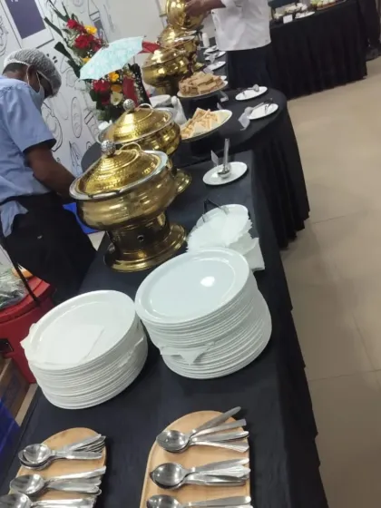 Our staff setting up a buffet line at a corporate office. We ensure every detail is taken care of, from the clean plates and cutlery to the perfectly arranged dishes.