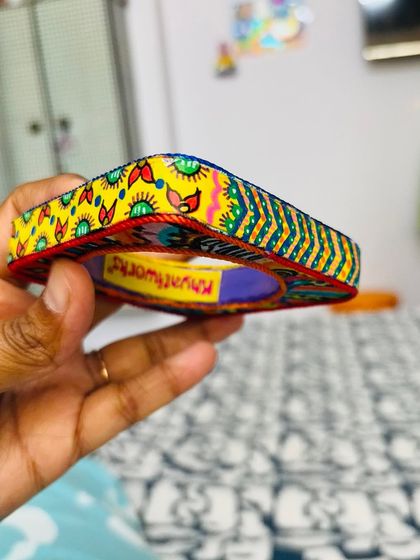 A different view of the Banjara Bangle, showing the hand-painted rim and the vibrant yellow fabric wrap with my original bird and leaf artwork.