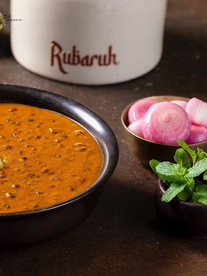 A close-up of Dal-e-Rubaruh, focusing on the creamy texture and the side of pickled onions.