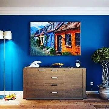 This colorful canvas painting of a European street scene brings vibrancy and character to the room. Landscape and architectural paintings are a wonderful way to personalize your space.