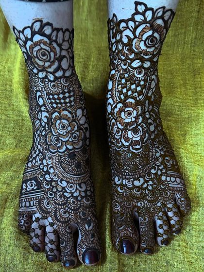 A high-quality, clear shot of the floral and checkerboard foot mehendi, showcasing the clean lines and precise application.