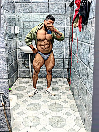 A full-body mirror selfie showing the shredded condition required for competition.
