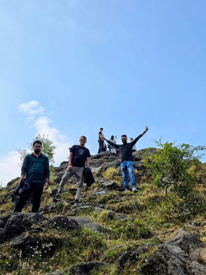 A triumphant moment for our group after reaching the top of a hill. The sense of accomplishment and the views are always worth the climb.