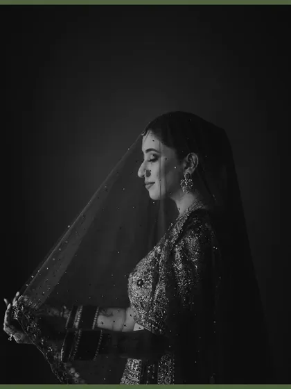 A classic black and white bridal portrait, with the veil creating a soft, ethereal glow around her. This timeless shot captures her grace and the quiet emotion of the moment.