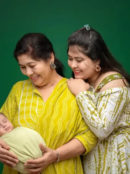 A truly special moment capturing three generations in one frame. A grandmother and mother lovingly look at their family's newborn baby, creating a timeless family portrait.