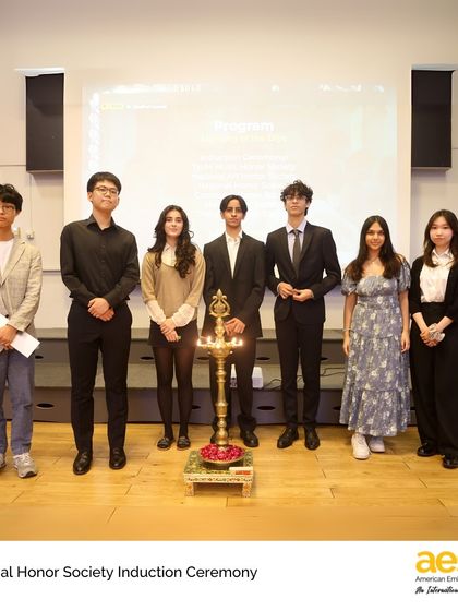 The officers of the National Honor Society stand by the ceremonial lamp. These student leaders are responsible for organizing service projects and upholding the society's values.