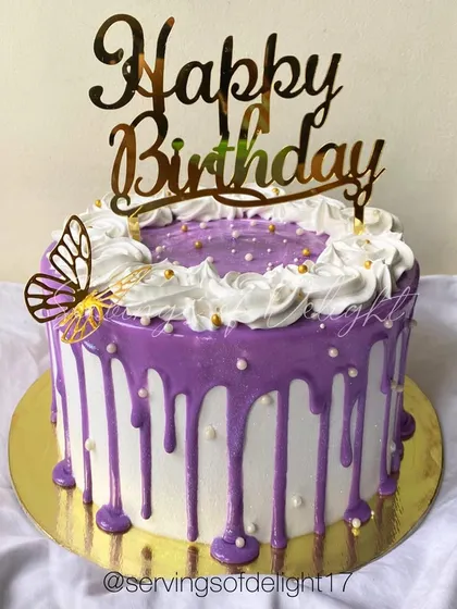 A purple drip cake with a butterfly accent. The combination of the vibrant drip and delicate topper creates a beautiful contrast.