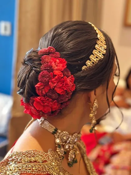 Another angle of the red carnation bridal bun, showing how the flowers are carefully placed to create a full, lush look. The style is both secure and visually striking from every viewpoint.