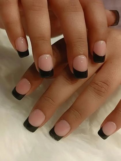 A chic and simple black French manicure on short, square nails. This is a modern and edgy alternative to the classic white tip.