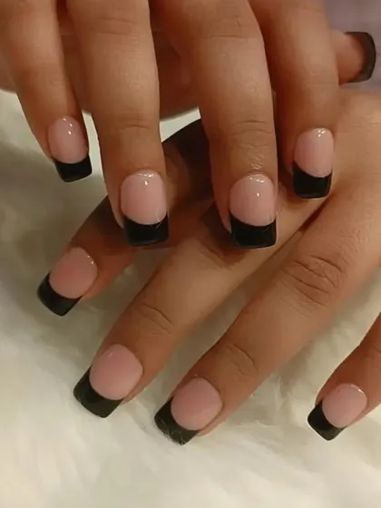 A bold and modern take on the French manicure. This style uses a natural nude base with solid, matte black tips for a high-contrast, edgy, and contemporary look.