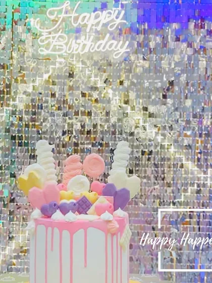 A cake that's almost too pretty to eat. This Candyland-themed cake is decorated with chocolate hearts, unicorn horns, and other sweet treats, set against a sparkling sequin backdrop.