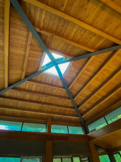 A vaulted wooden ceiling with a central skylight, designed to draw natural light deep into the home. This architectural detail adds volume and a connection to the sky above.