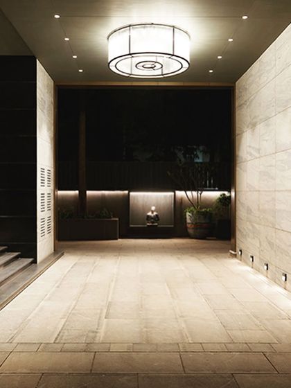 The main drop-off lobby is illuminated by a dramatic, custom-designed 6-foot-wide light fixture, creating a welcoming and impressive entrance for residents and guests.