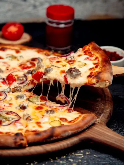 The perfect cheese pull from a slice of our freshly baked pizza, loaded with toppings and gooey mozzarella. A crowd-pleaser at any event.