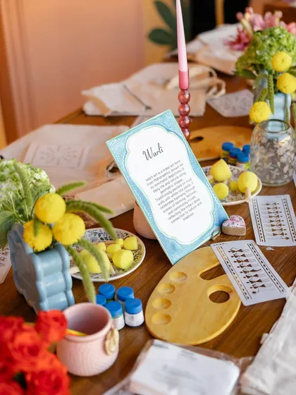 The art station supplies, including stencils for Warli art, paints, and palettes, all beautifully arranged for guests.