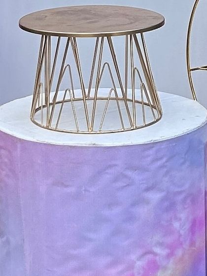 A themed pedestal with a pastel, watercolor-style print, topped with a modern gold wire cake stand. This shows how I coordinate all elements of the decor.