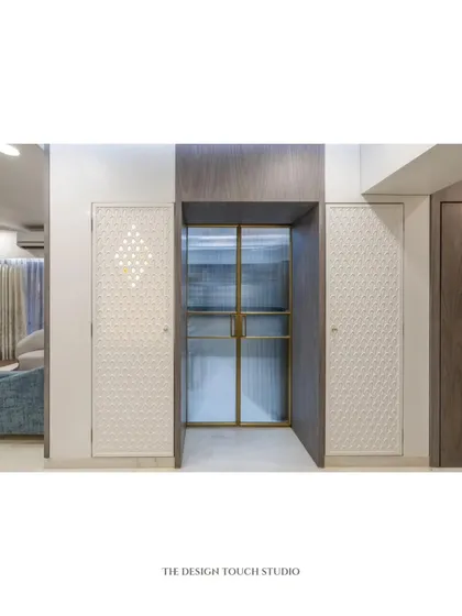 A full view of the mandir unit, flanked by a modern fluted glass door. The design shows how a traditional element can be seamlessly integrated into a contemporary home.