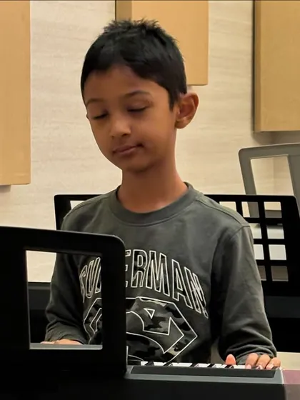 It's more than just learning notes. It's about finding a passion, as seen here with a young student completely absorbed in his piano practice.