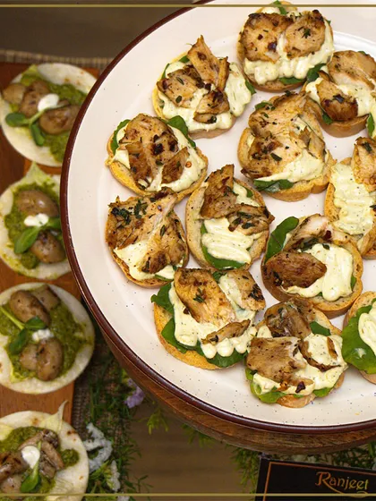 A platter of savory canapés, featuring grilled chicken on a bed of greens. Each appetizer is carefully constructed for the perfect balance of flavor and texture.