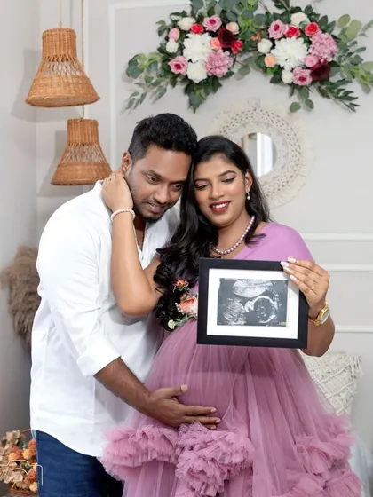 A precious moment as the couple holds up a sonogram picture, their first glimpse of their baby, surrounded by the warm boho decor.