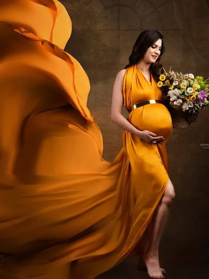 Capturing the beauty of movement, this shot features a flowing mustard-colored gown tossed to the side. The client holds a basket of flowers, adding a rustic and charming element.