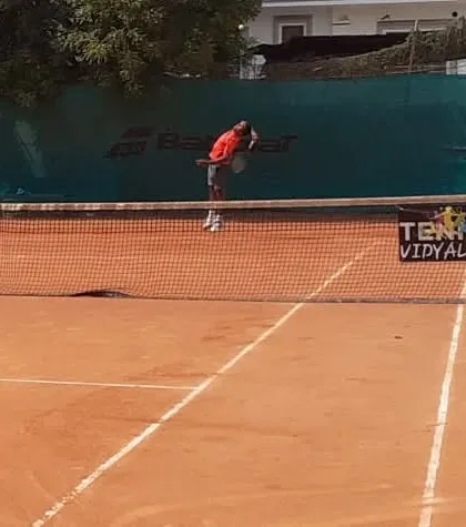 A player executing a powerful serve during the 4th Shri Rajesh Patel Memorial Super-Series.