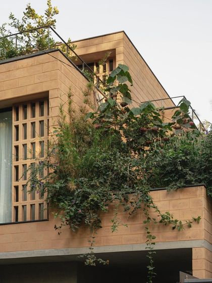 The upper levels of the Debris Block House feature balconies with integrated planters, allowing residents to be surrounded by greenery even on a compact urban plot.