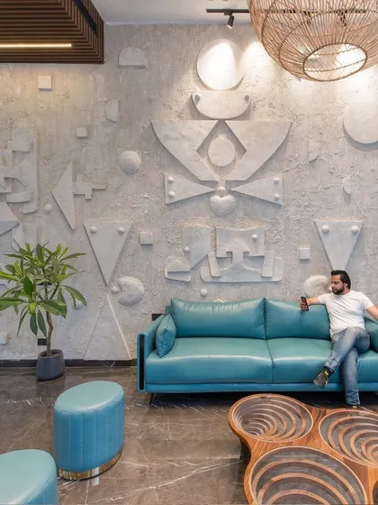 Another angle of the drawing room, showing our principal architect enjoying the space. The custom-carved wooden coffee table is a functional piece of art.