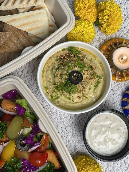 A close-up of the fresh salad and creamy hummus from our party platter. We use only the freshest ingredients to make your celebration special.